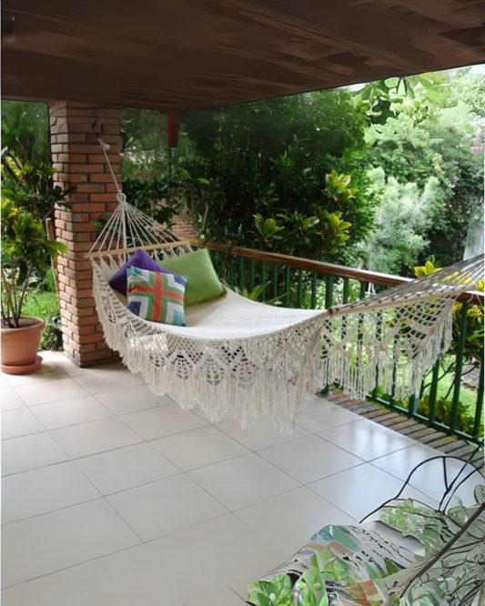 Weiße handgemachte Hängematte mit Makrame aus Lateinamerika auf einer Terasse