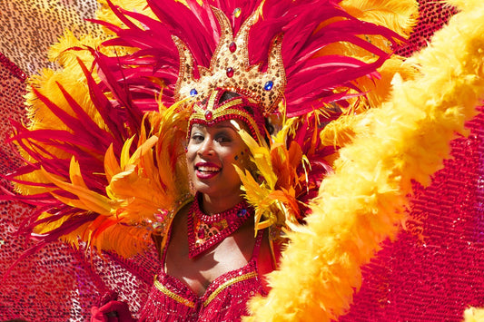 Eine Frau in einem rot-orangenen Karnevalkostüm mit Federn in Rio de Janeiro, Brasilien