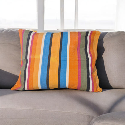 Orange-farbenes Kissen Mango auf einem Sofa im Wohnzimmer aus 100% Baumwolle, hergestellt in Lateinamerika