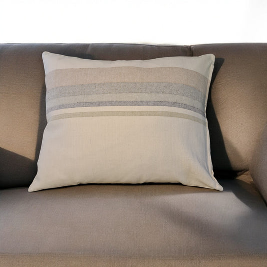 Kissen Paz in hellen Naturtönen auf einem Sofa im Wohnzimmer aus 100% Baumwolle, hergestellt in Lateinamerika